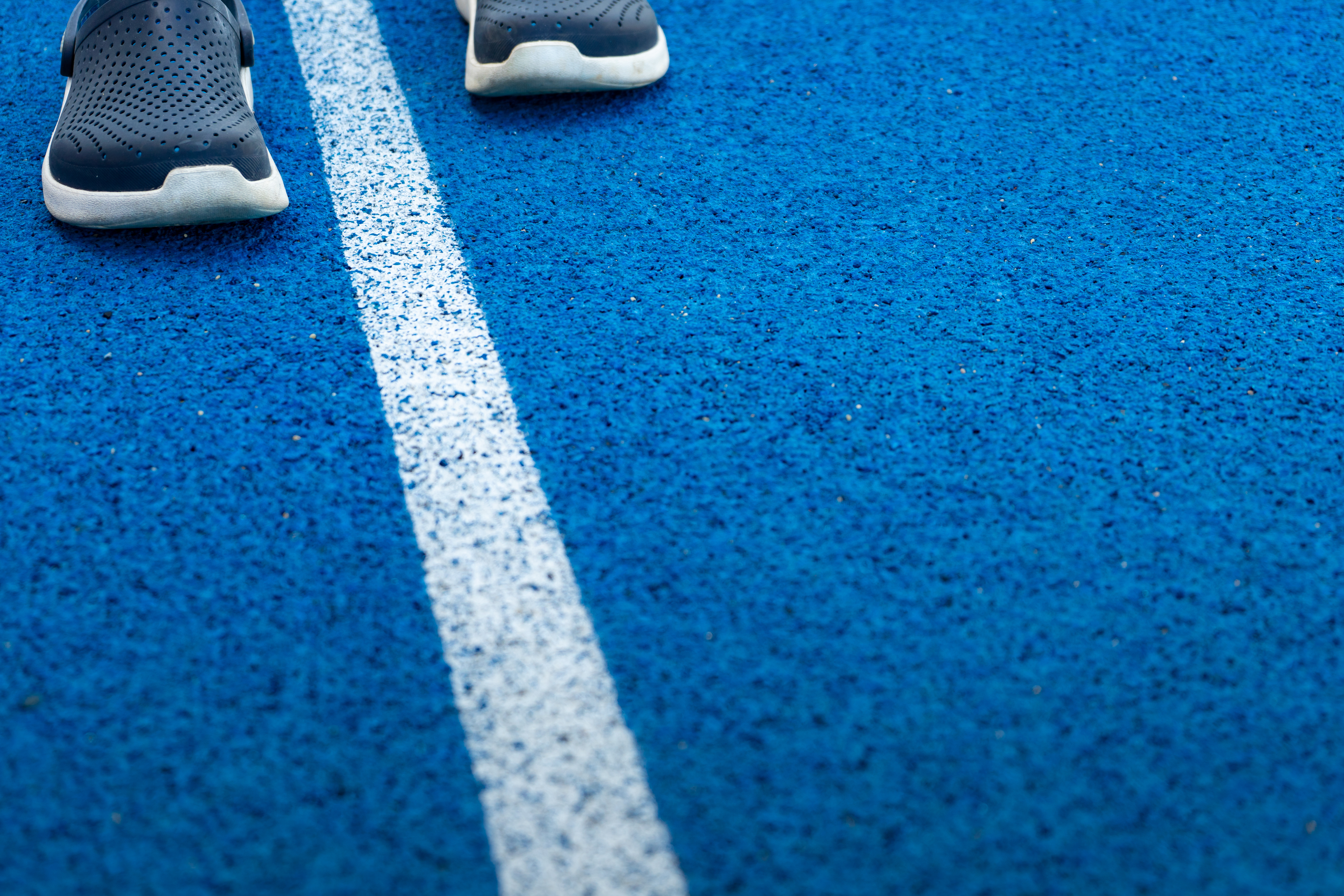 Person walking on blue rubber track