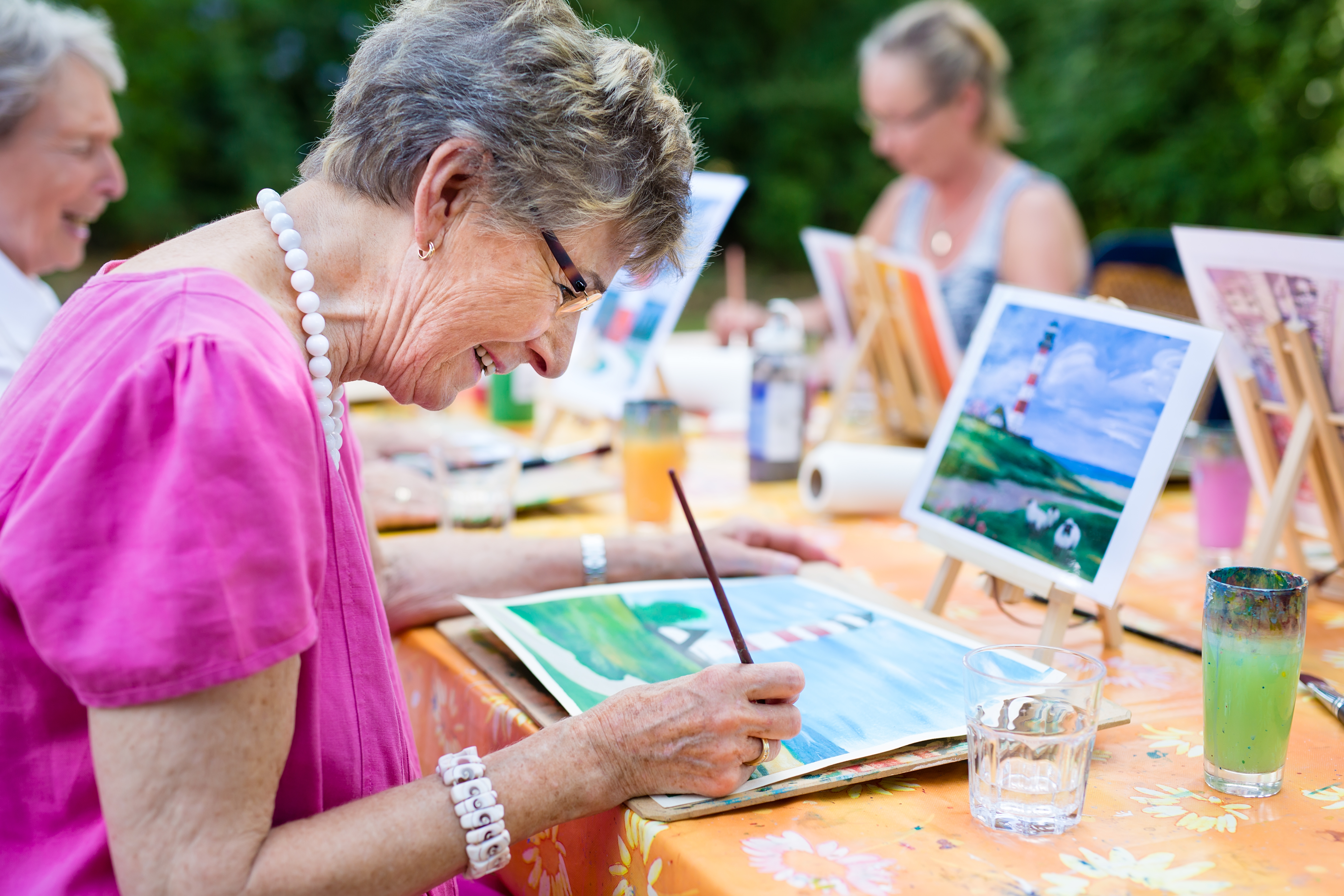 Older woman painting with group of people