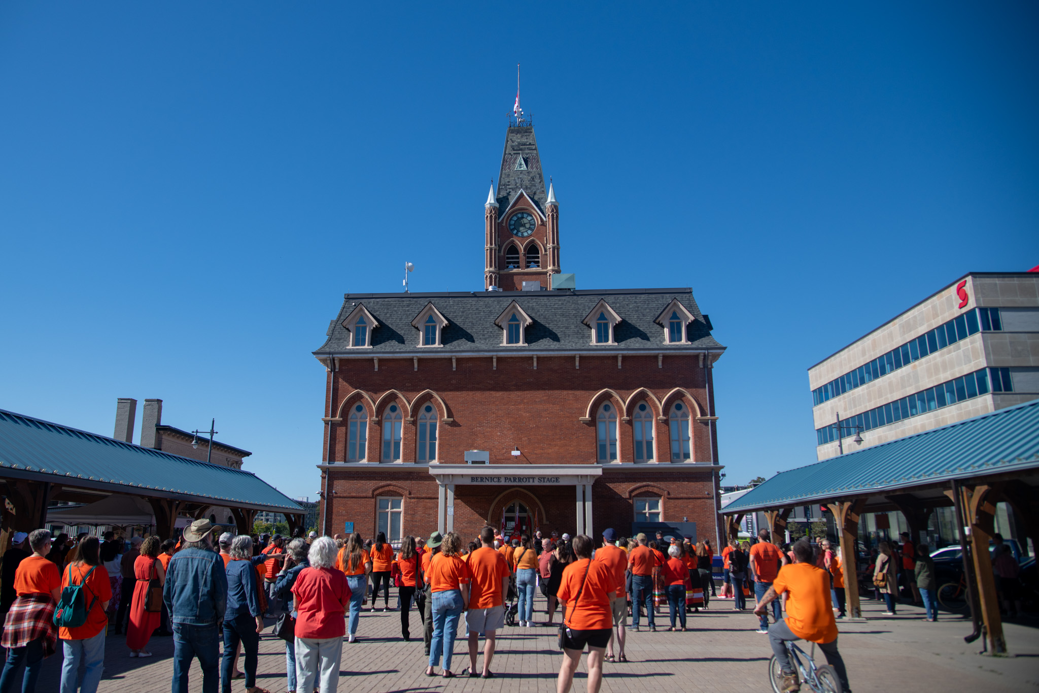 Group of people in orange shirts standing in market square
