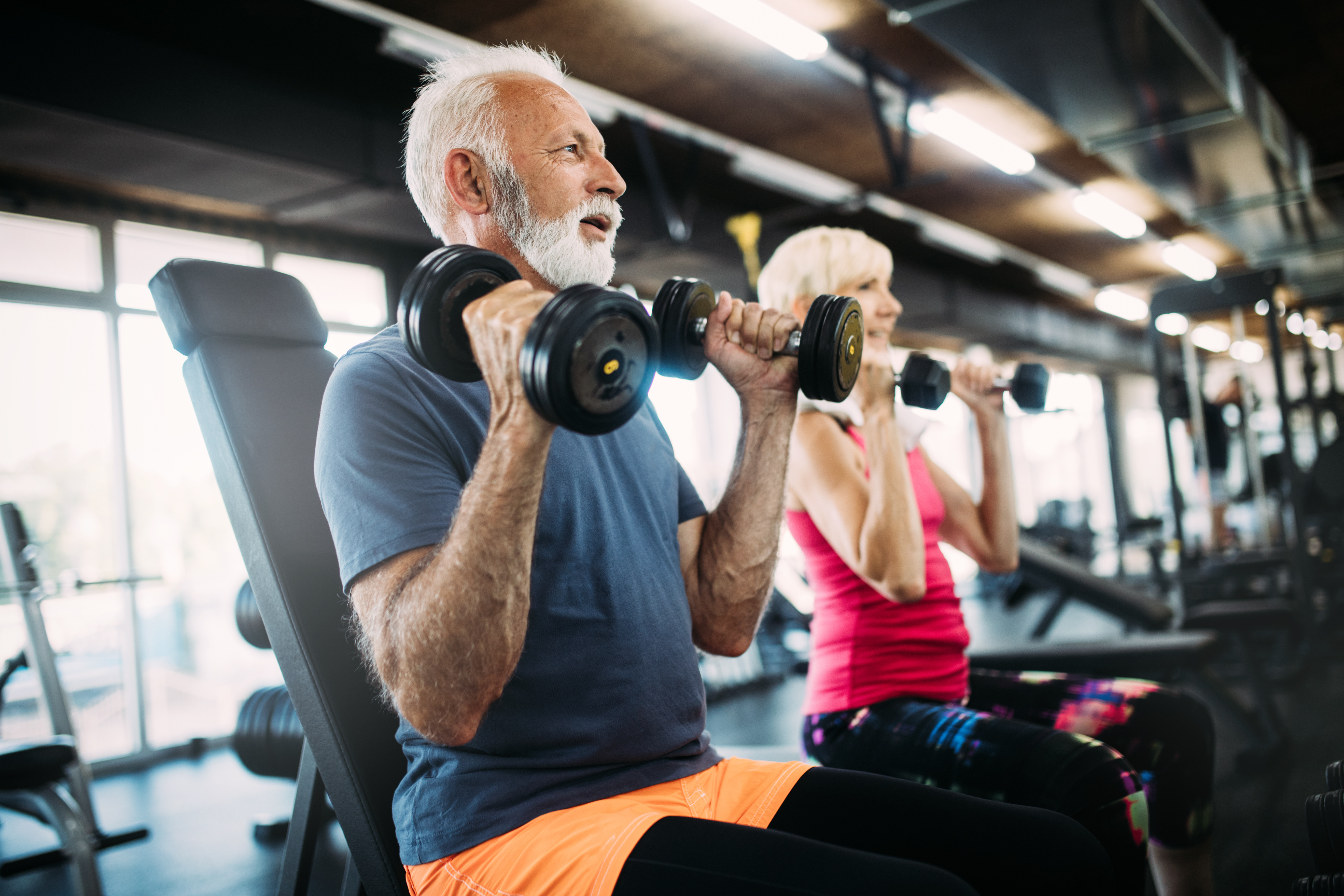 Older man and woman lifting weights