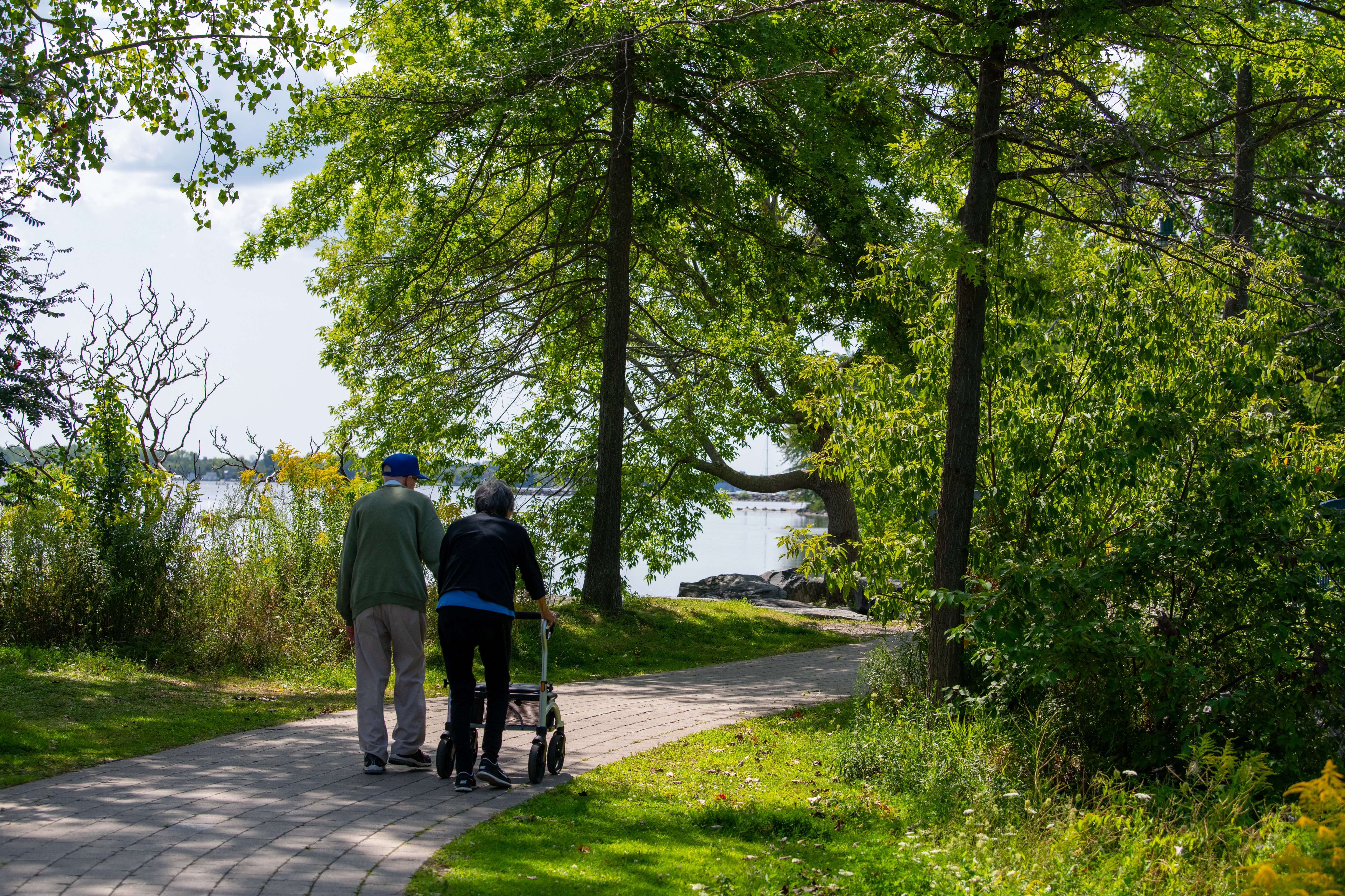 Couple walking down trail with walker