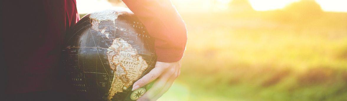 A person holding a globe at their side