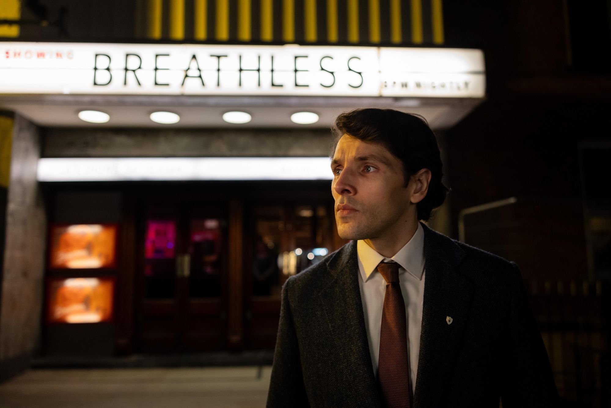 Man standing outside of a movie theatre
