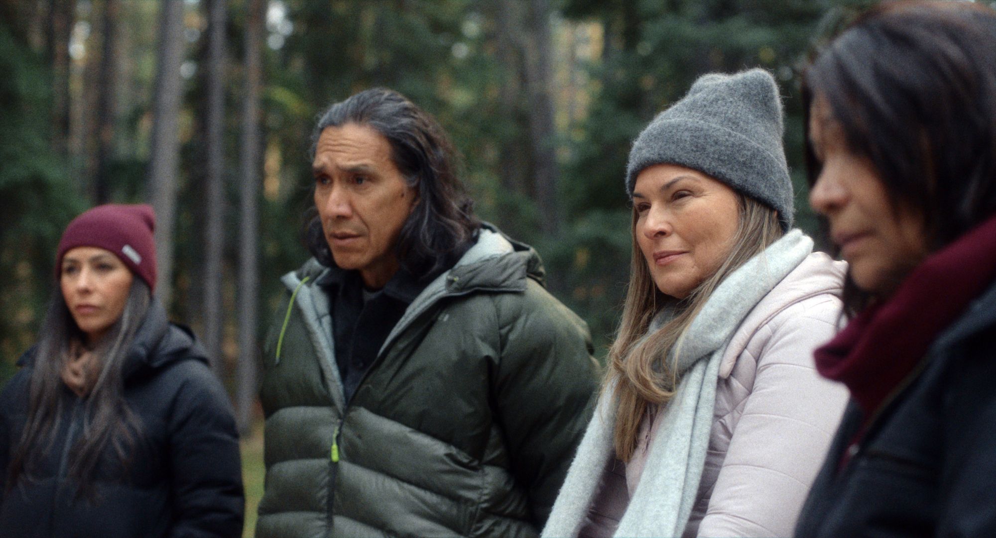 Four people standing in a forest