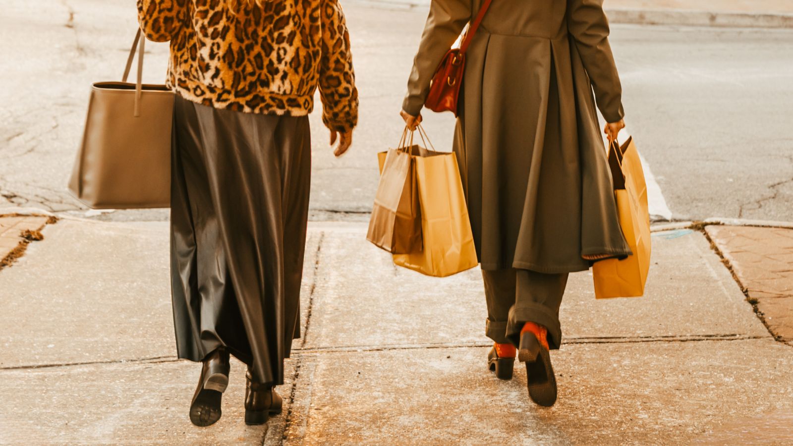 View from behind of two people shopping in downtown Port Perry with large purses and shopping bags