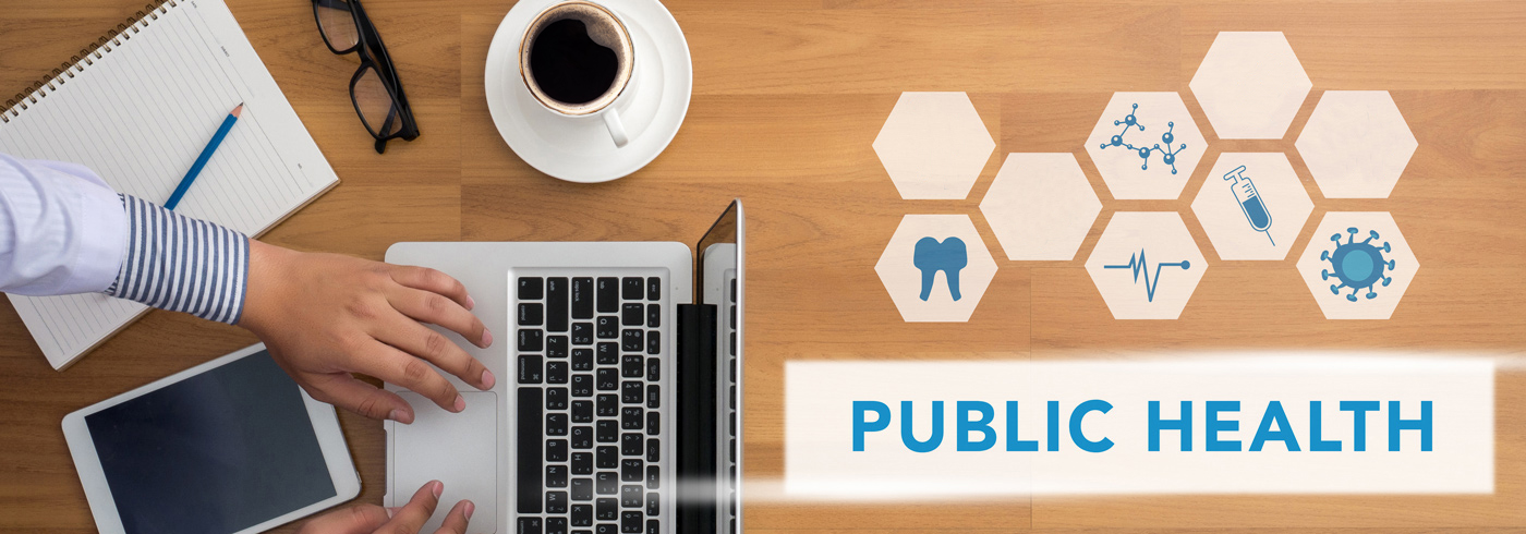 A person is typing on a laptop at a wooden desk with a cup of coffee, a tablet, and a notebook. Nearby are icons related to public health, including a tooth, heartbeat, and virus. The words "Public Health" are prominently displayed.