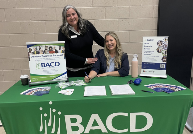 BACD’s Patrice Esper standing and Ashley McBride seeated at table with BACD promotional material.