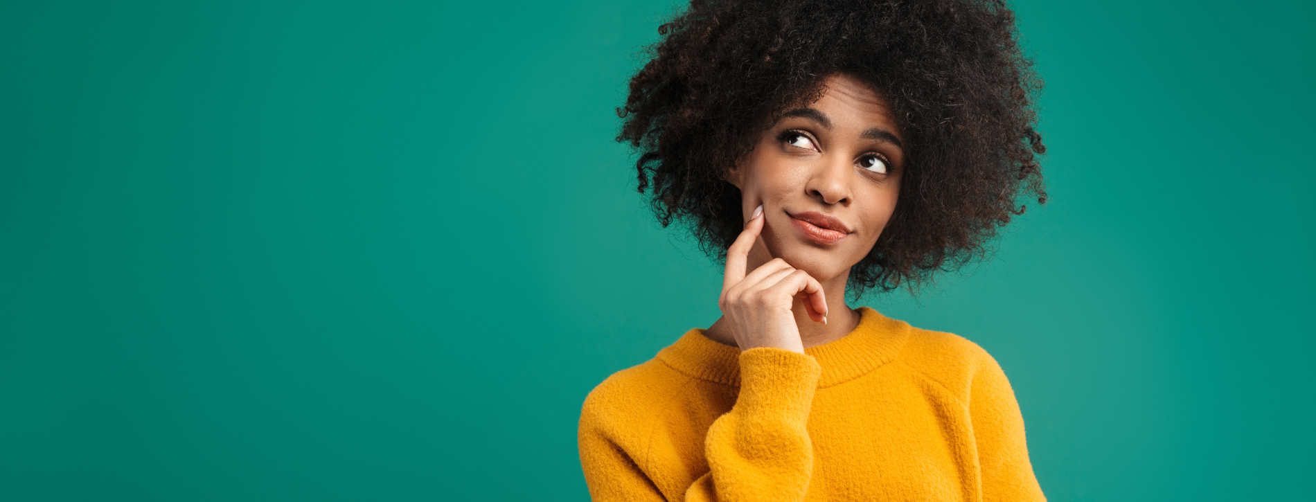 Person in a yellow sweater looking thoughtful against a teal background.