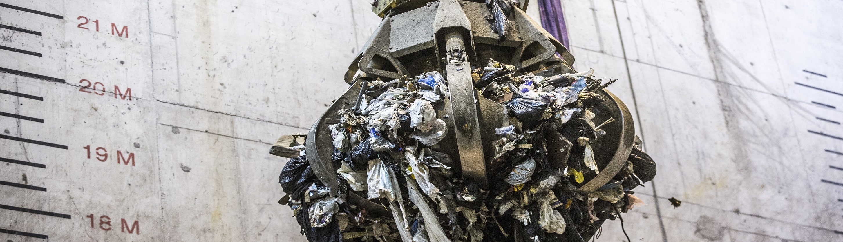 Close view of the grapple crane holding waste.