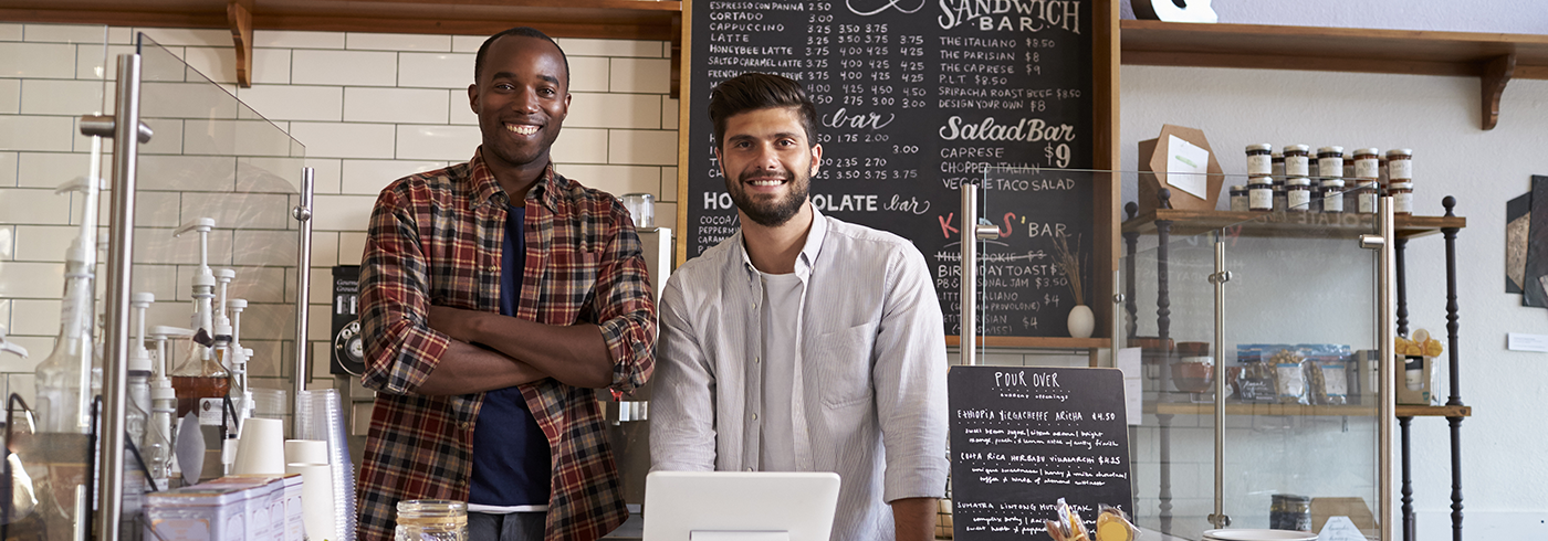 Two staff standing behind counter at a business