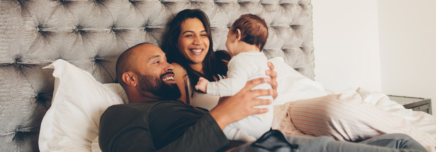 Couple interacting with new baby at home