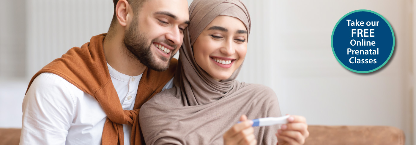 Couple smiling at a home pregnancy test