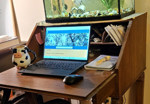 The vintage secretary desk given to Erica showcasing her laptop and desktop items.