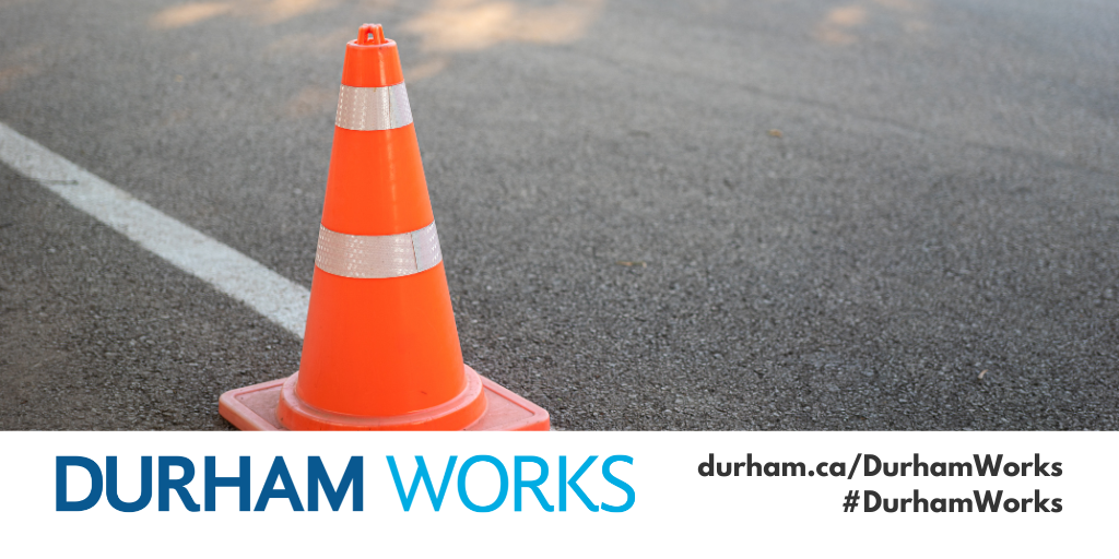 An image of a pylon on a road next to a white line, with a Durham Works logo banner and text reading durham.ca/DurhamWorks #DurhamWorks