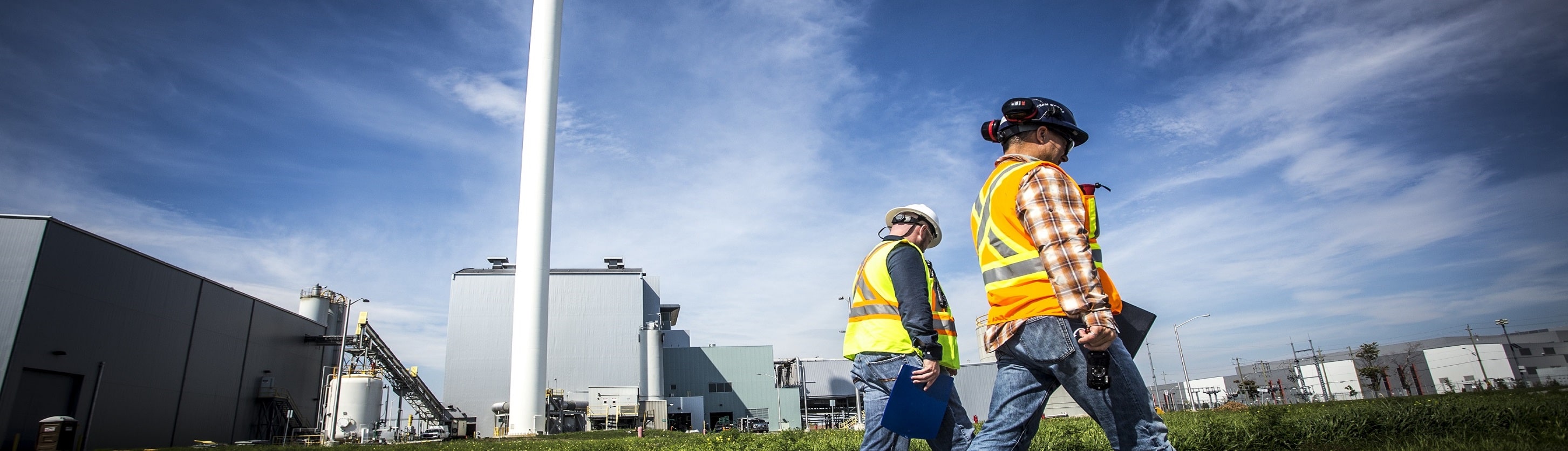Two people in safety vests outside the Durham York Energy Centre.