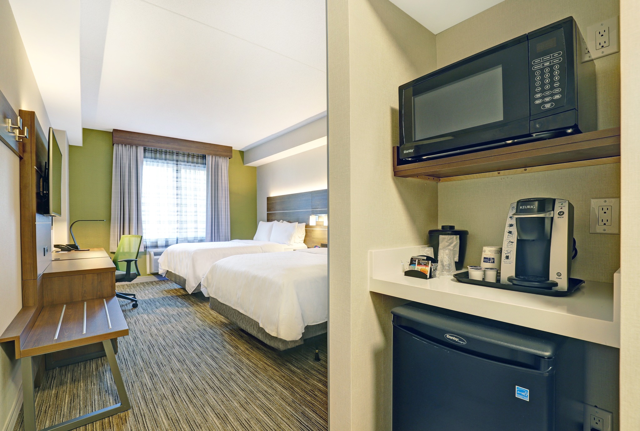 Hotel guest room with king bed and kitchenette with mini fridge and microwave