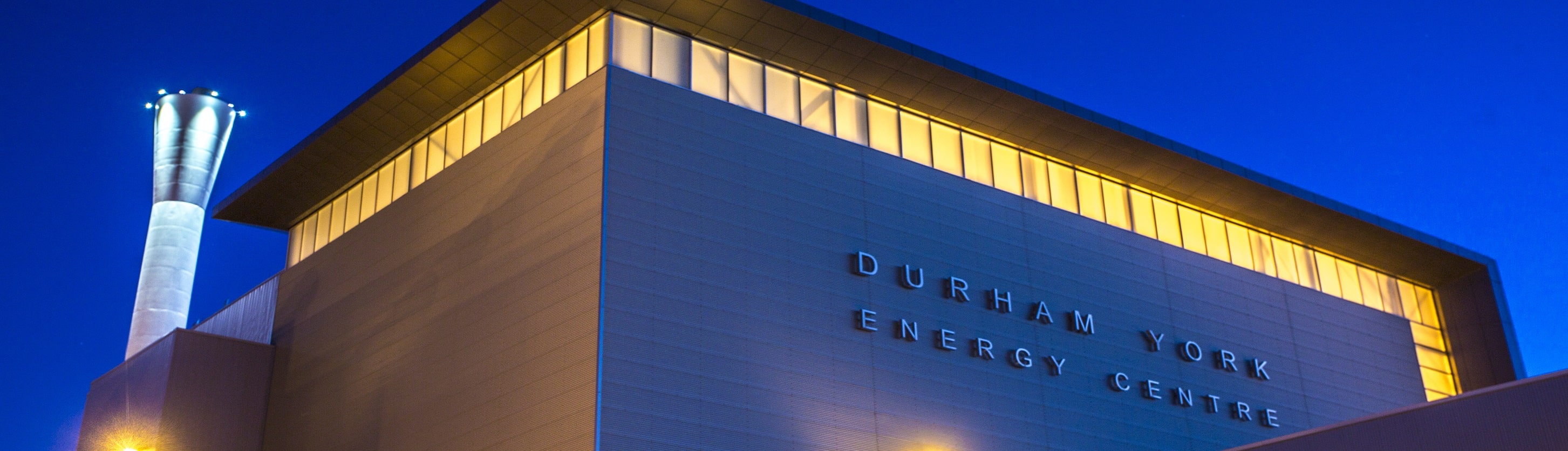 Exterior view of the Durham York Energy Centre building sign at night.