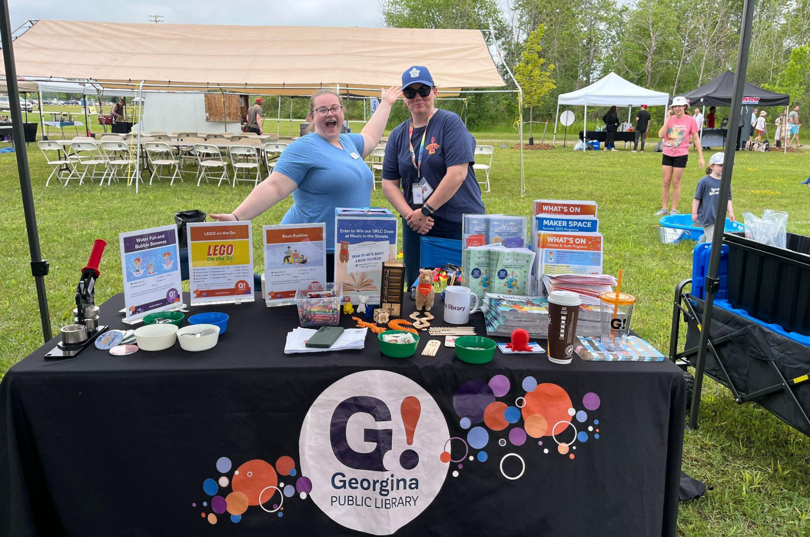 2 people standing at a Georgina Public Library outreach table