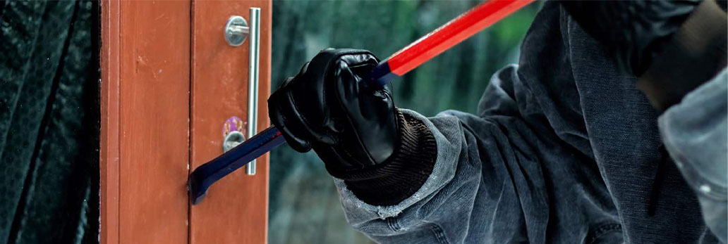Someone trying to open a door with crow bar