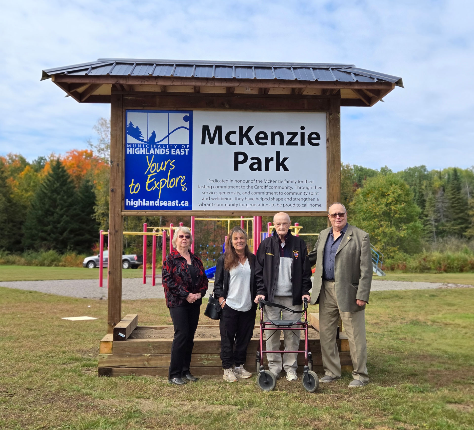 Mayor Burton with councillors Lewis and Strong pose with councillor Cam McKenzie in front of the McKenzie Park sign on dedication day.
