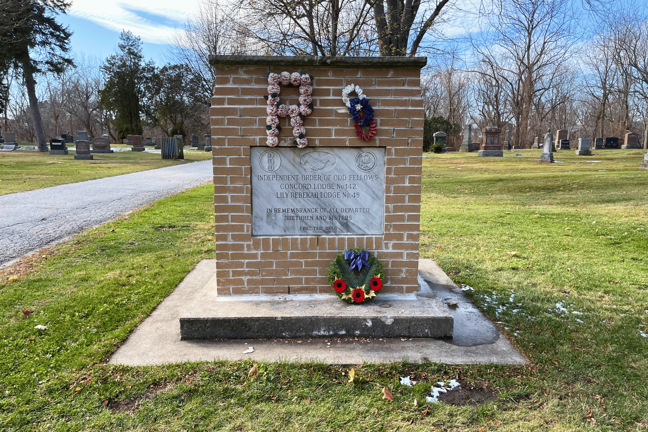 Cemetery monument with wreaths and foliage