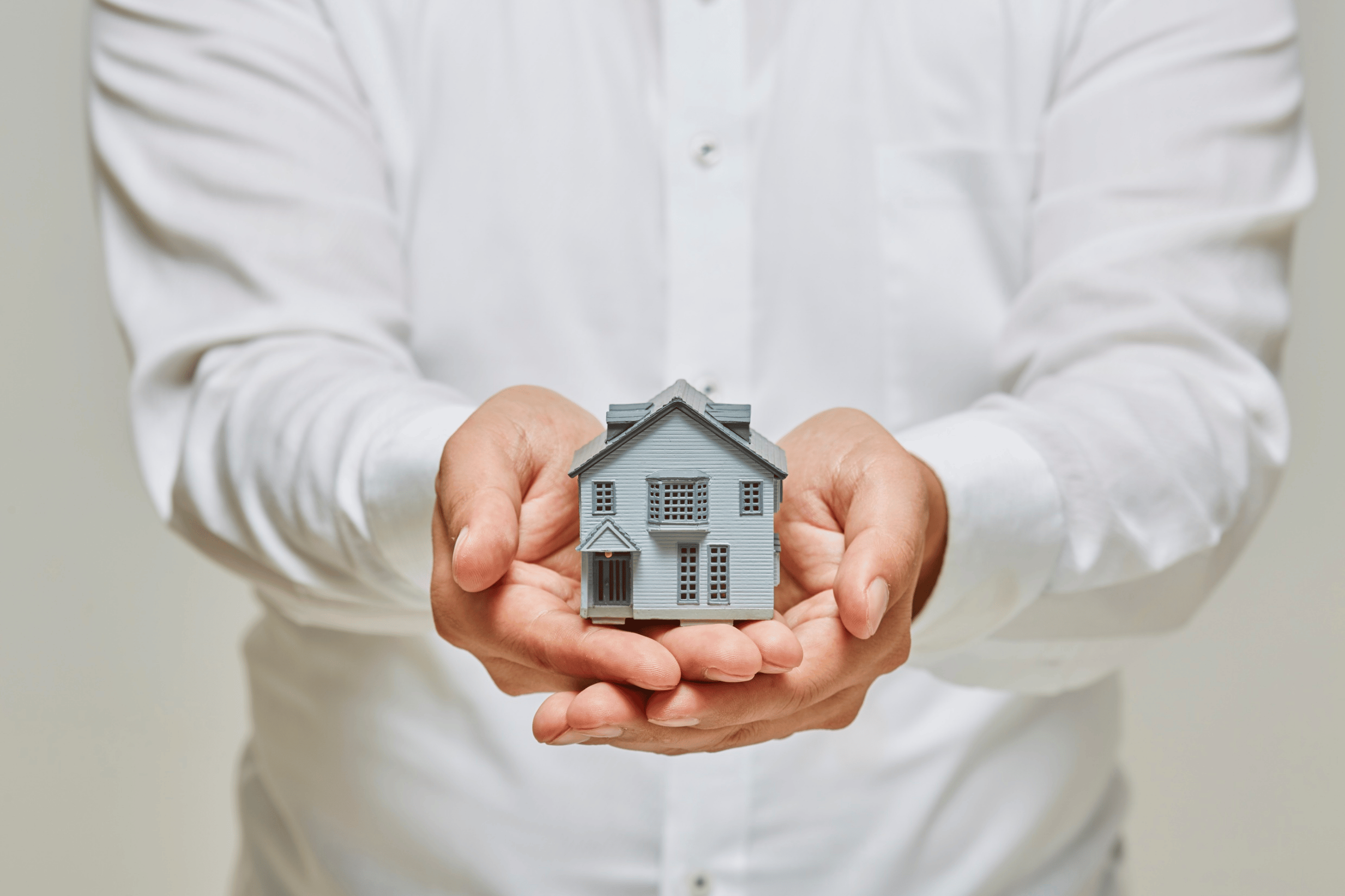 Hands hold a house