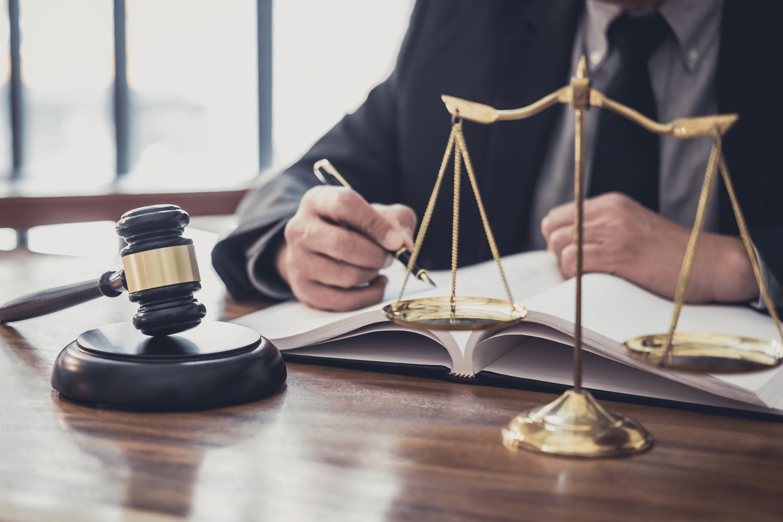Man, surrounded by mayor's gavel and balance scale reviews paperwork