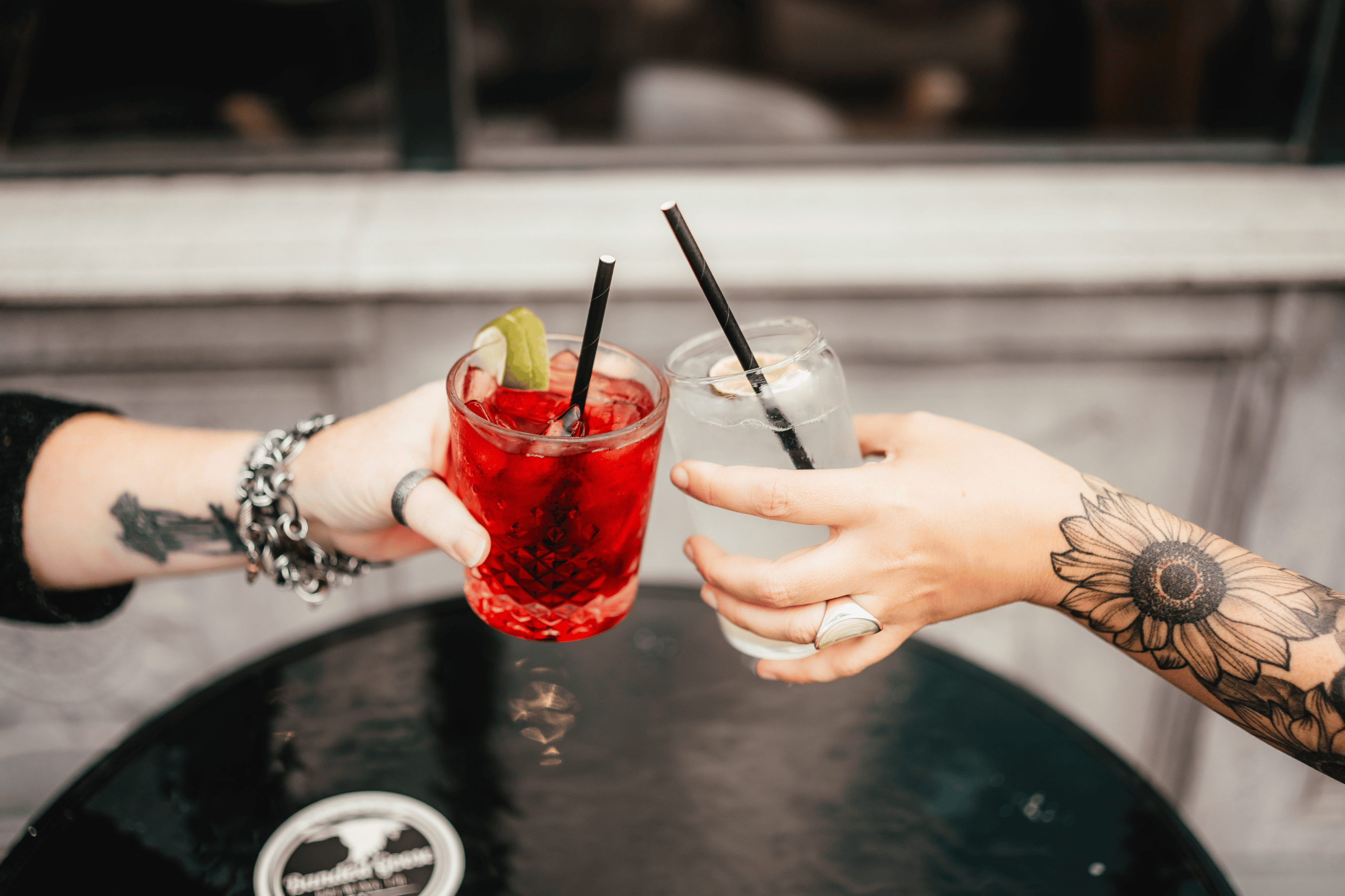 People cheers fancy drinks over an outdoor patio table