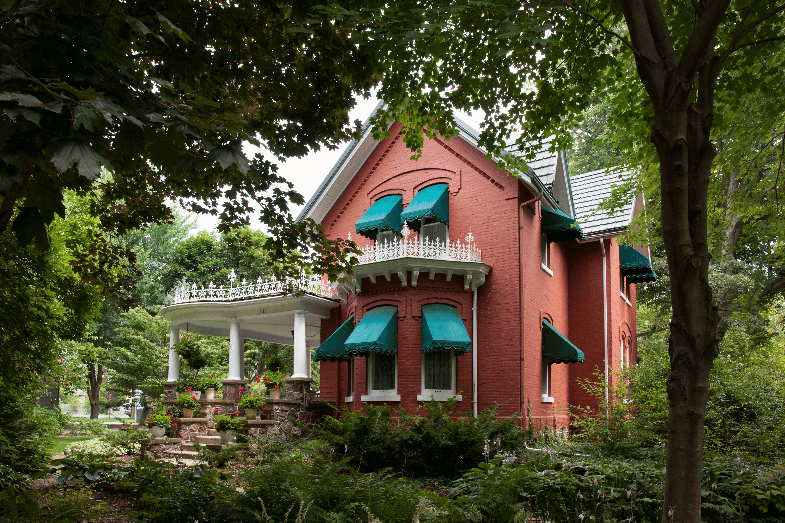 Red brick house with green awnings