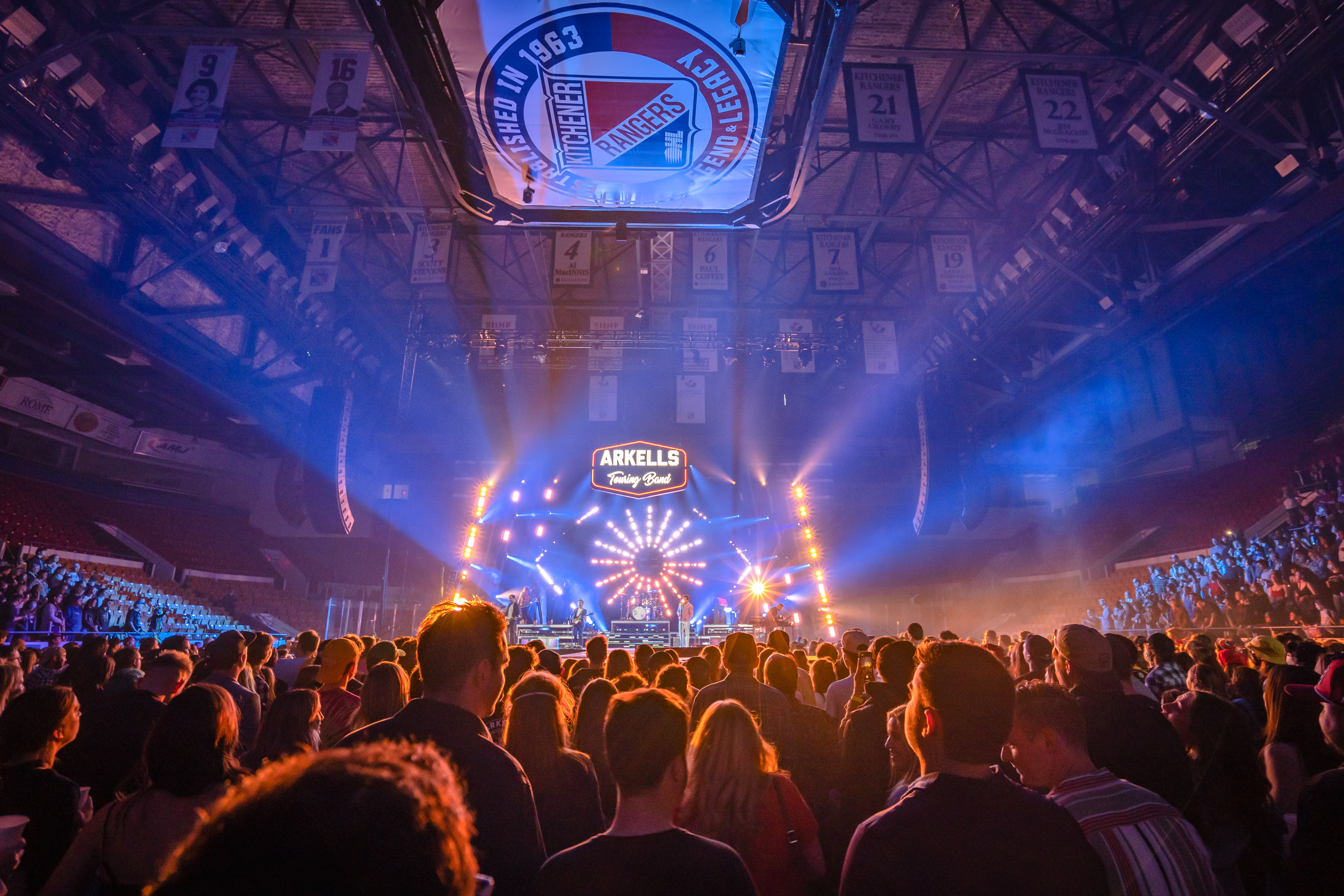 Crowd of people watching band on stage performing