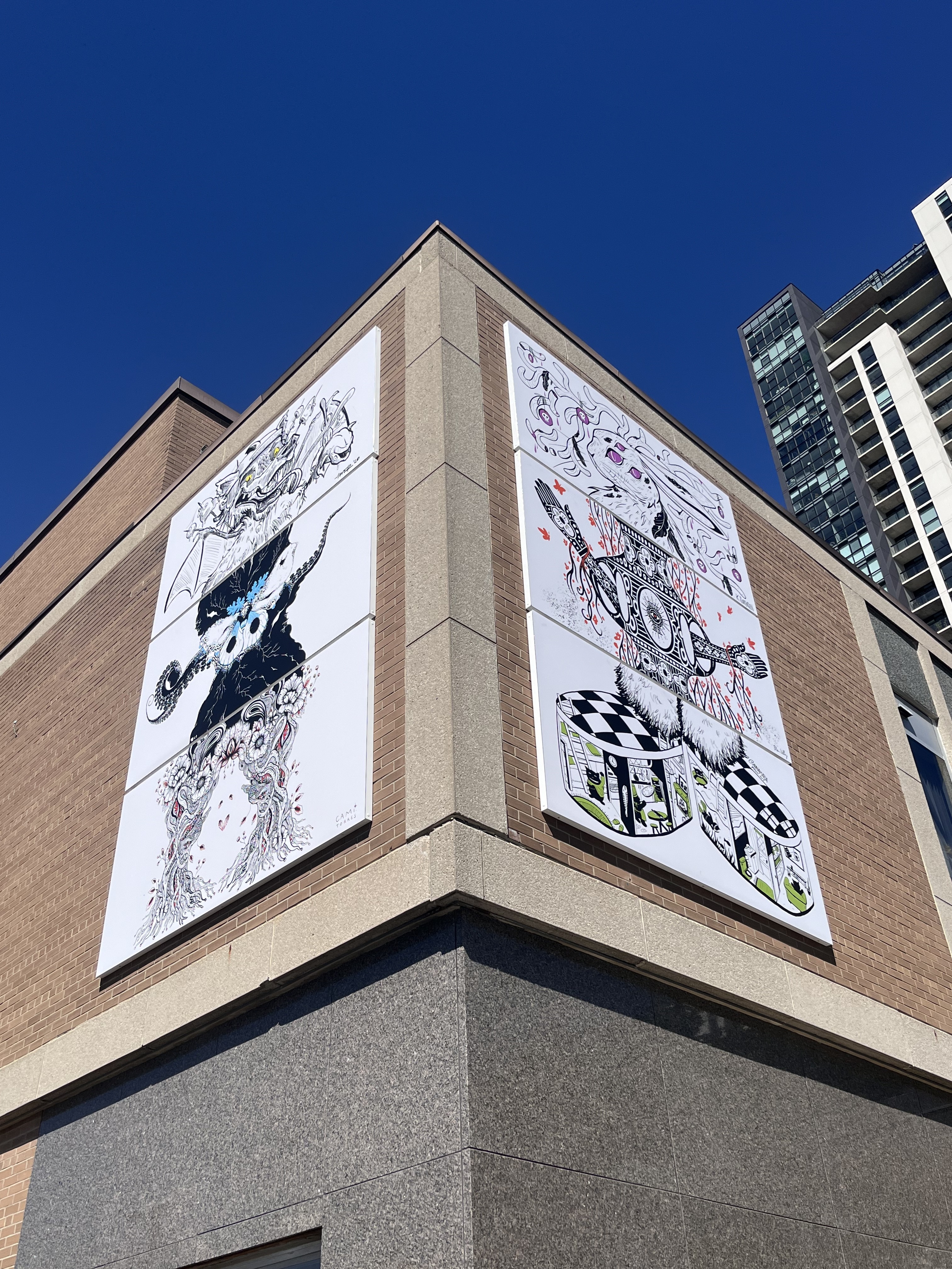 two murals on the outer corner of a building with animals