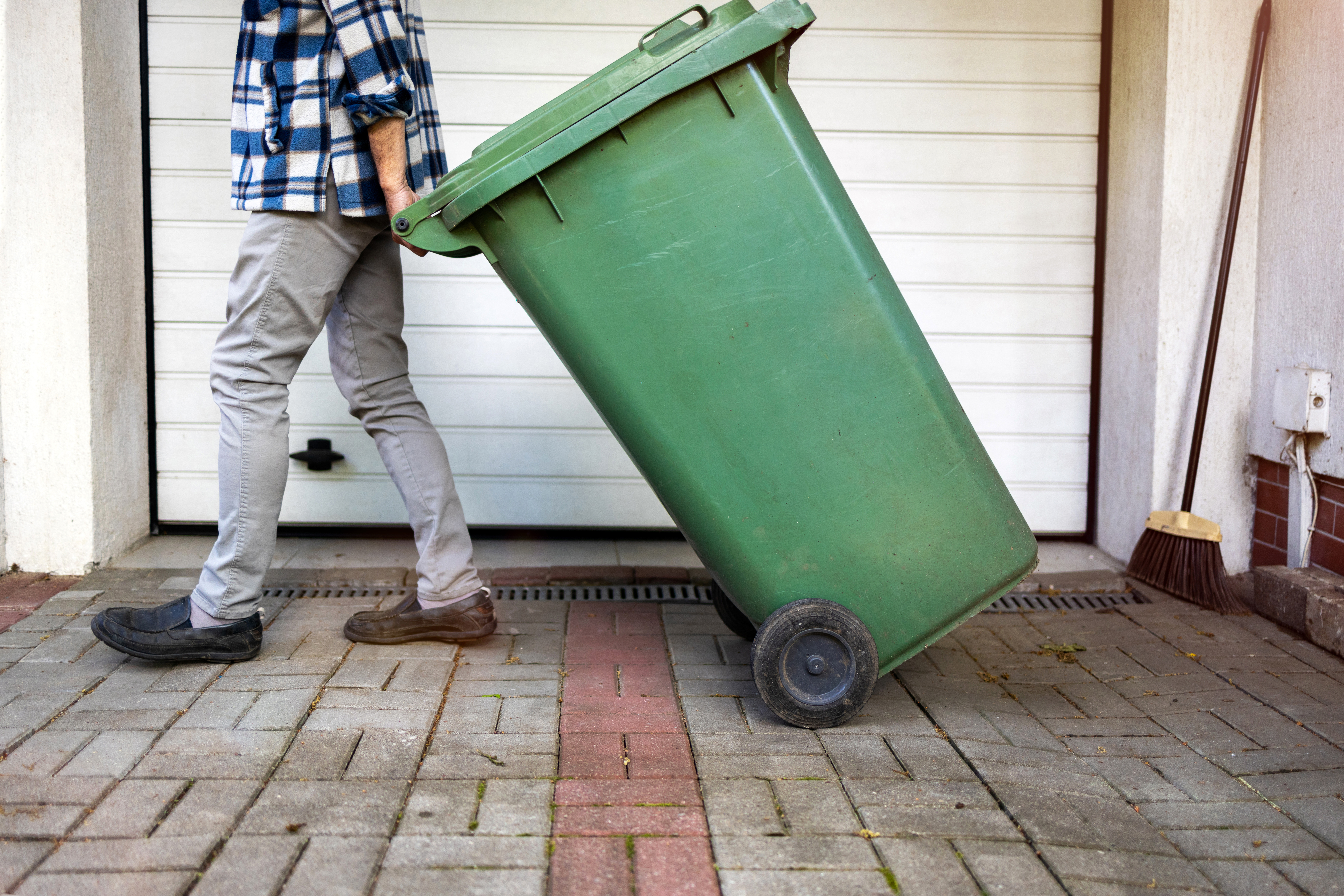 Person moving garbage bin.