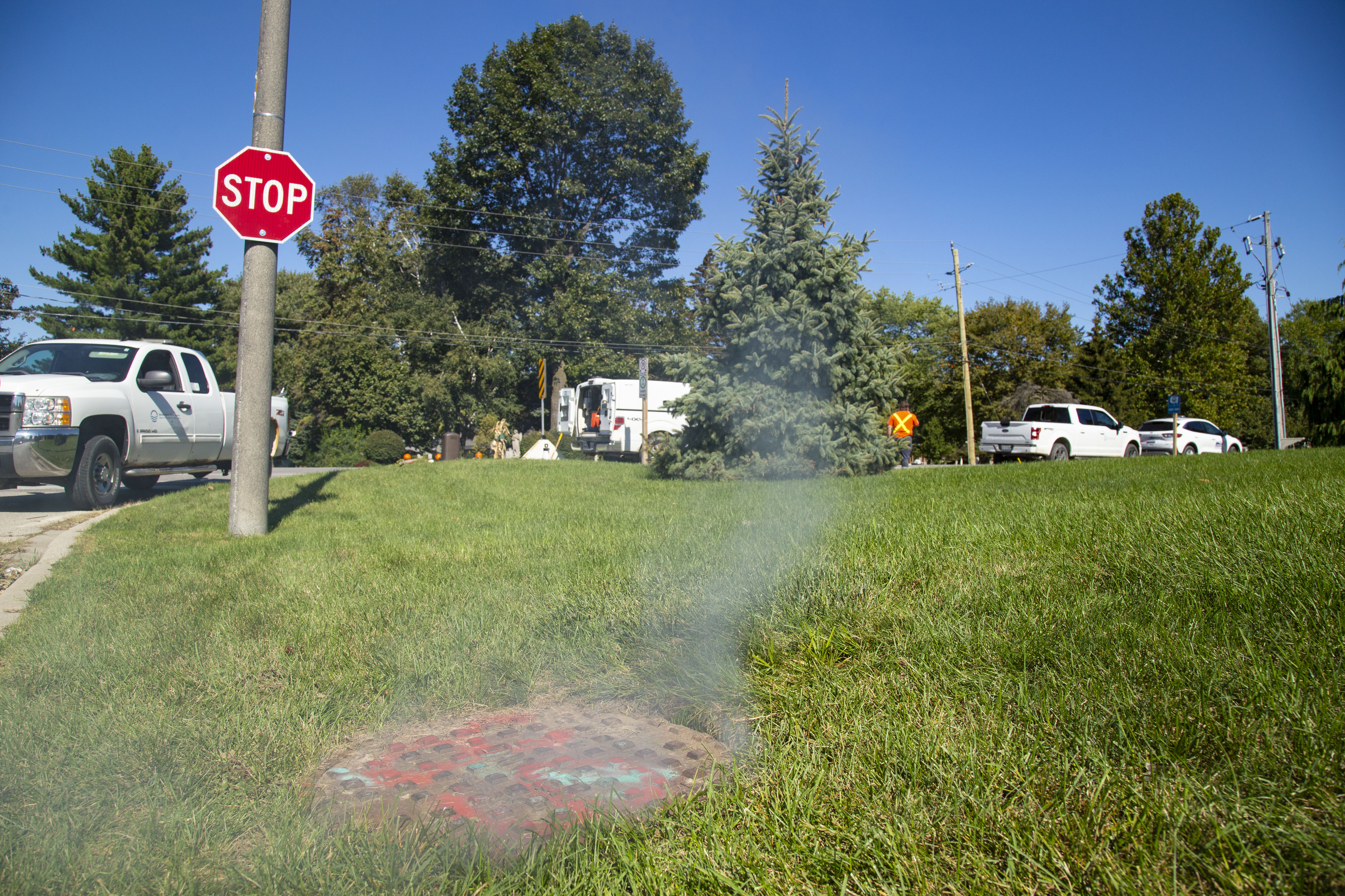 Sewer showing white vapour coming out of it in a residential area.