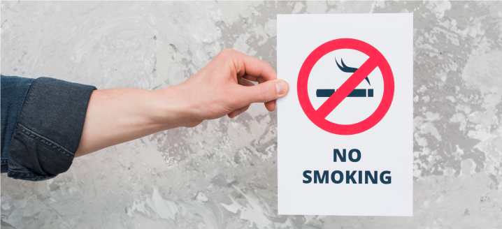 hand holding a no smoking sign