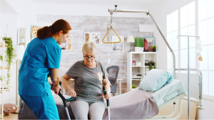 staff person assisting senior with walking aide