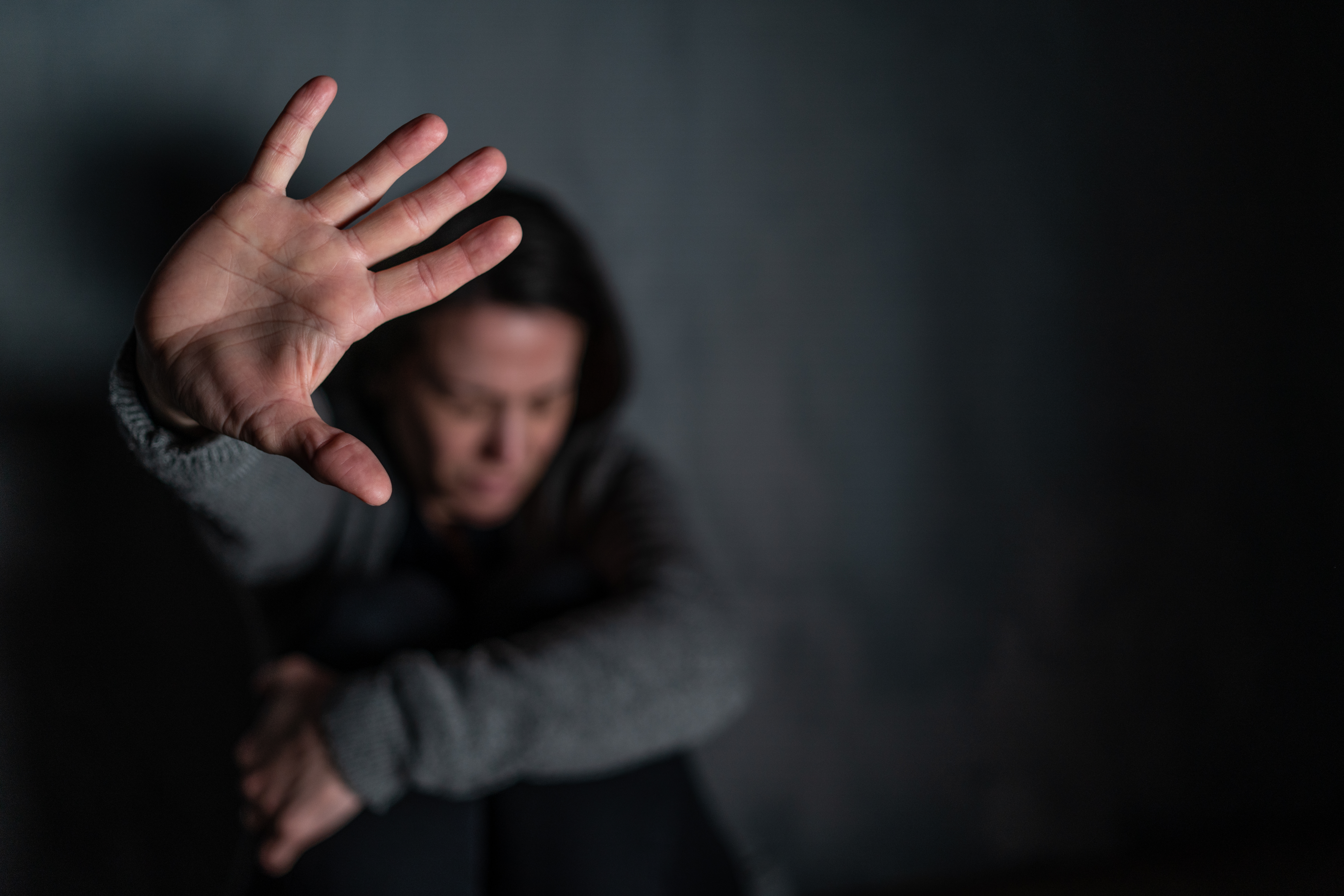 Blurred Figure With Hand Raised To Block View