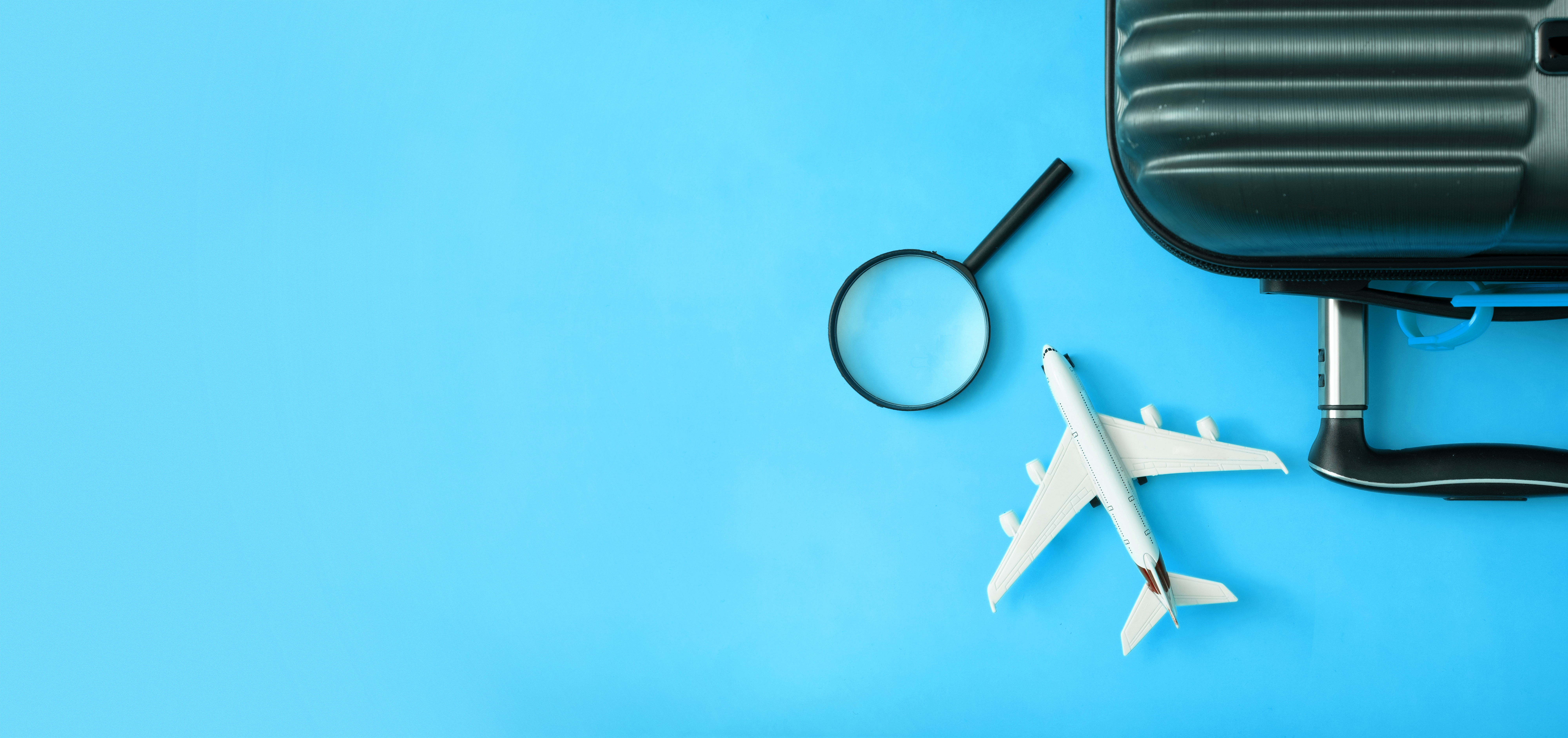 Airplane Model With Magnifying Glass And Luggage