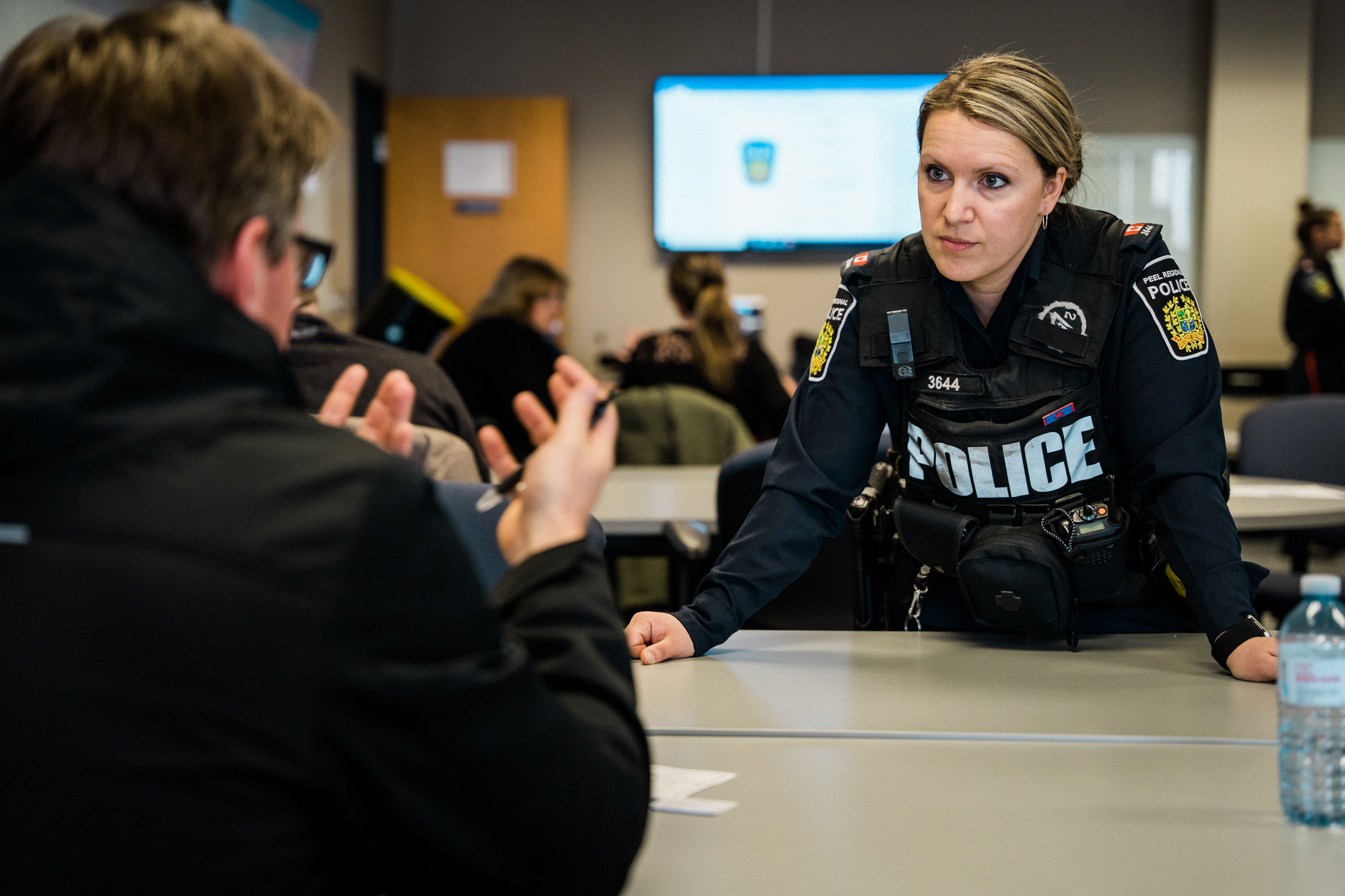 Police officer interacting with student in classroom
