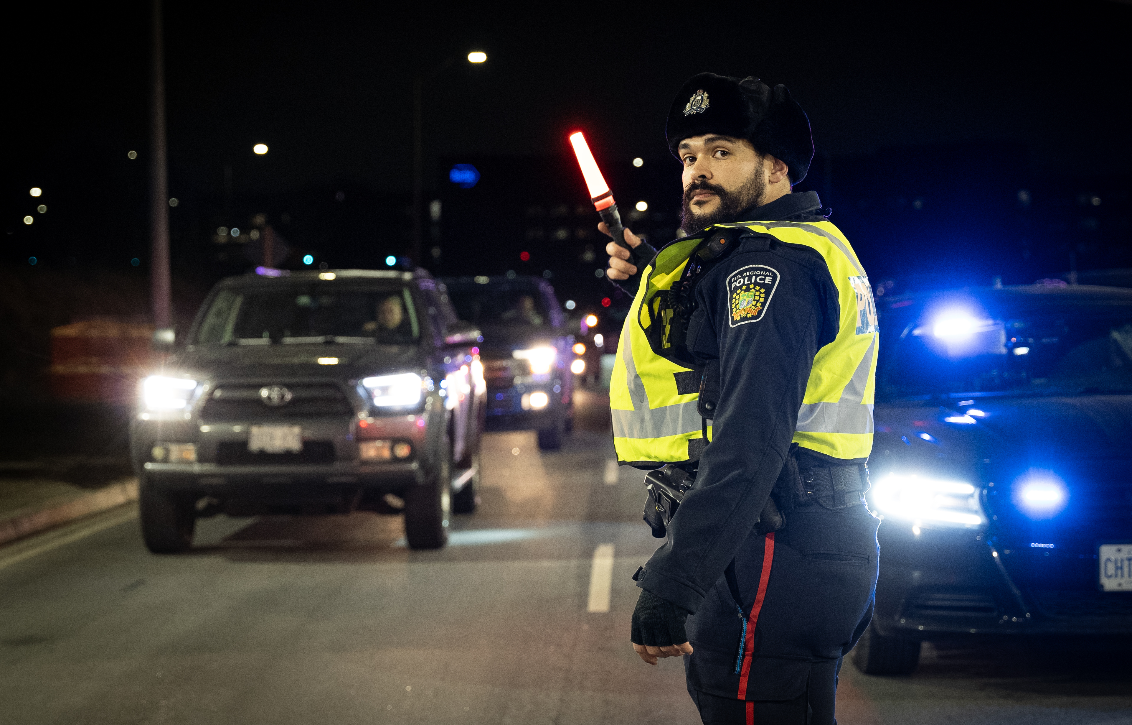 Police officer directing traffic at night
