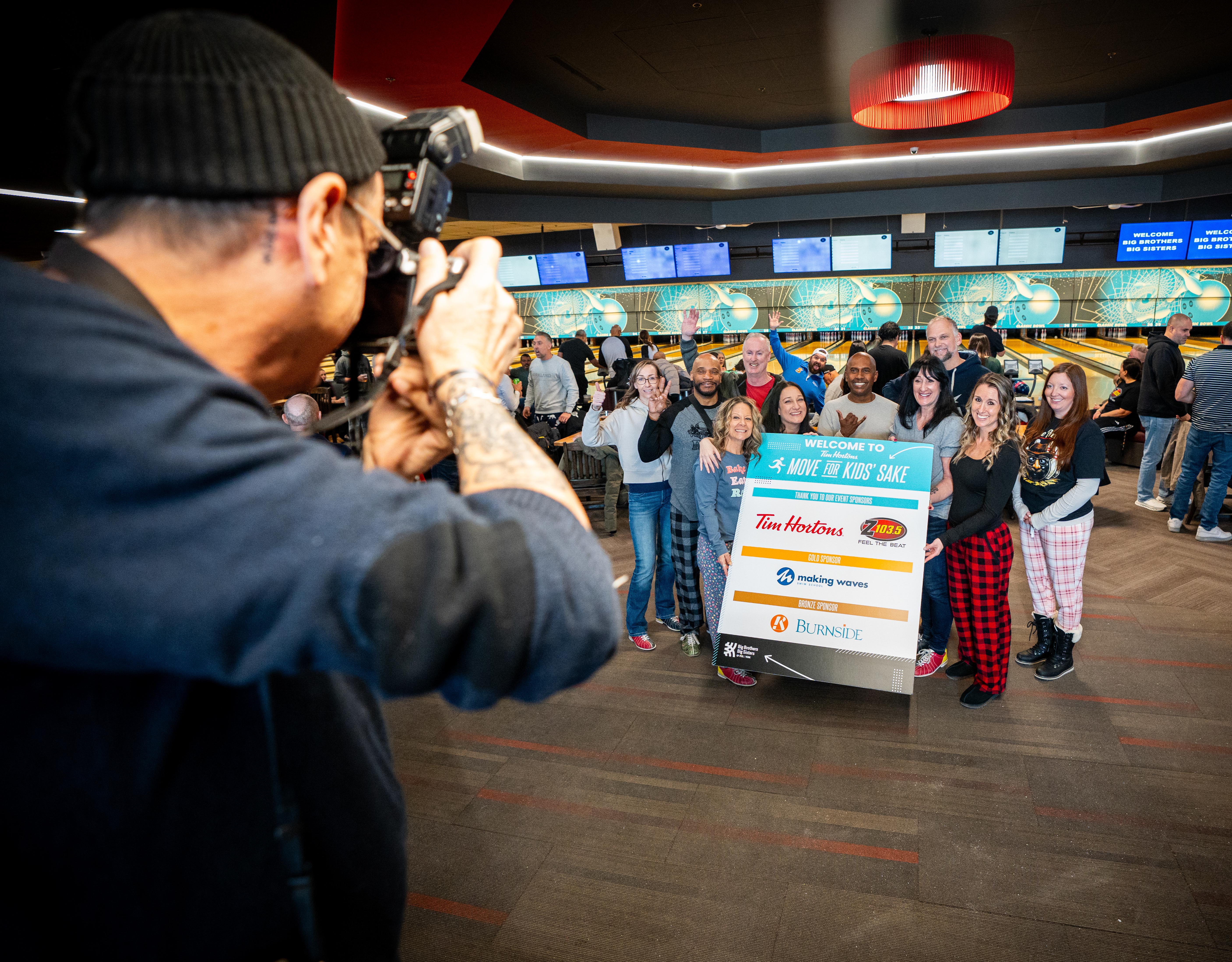 Photographer taking group photo at bowling alley
