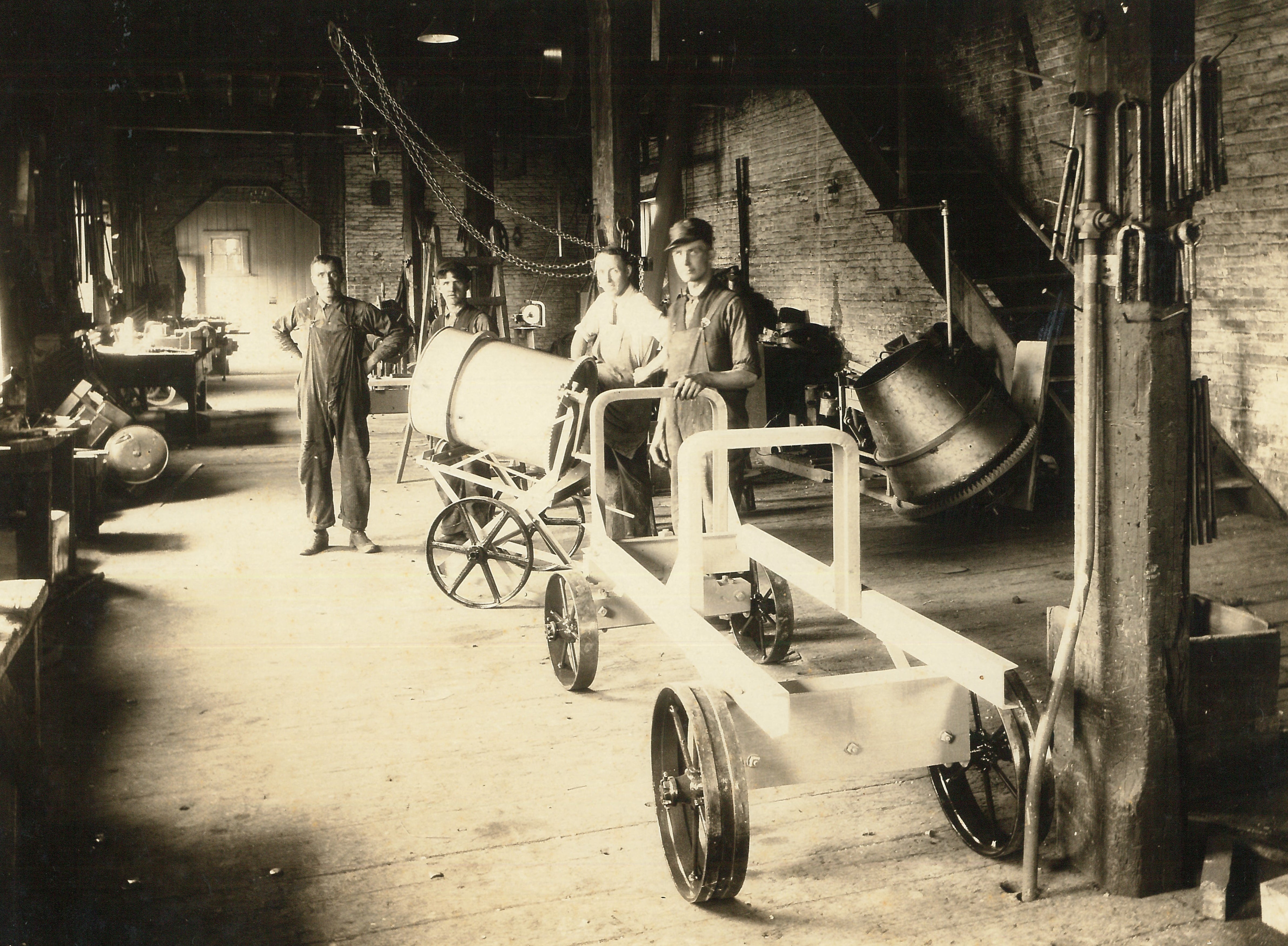Interior of the Wettlaufer foundry; workers are posing with cement mixers and other equipment.