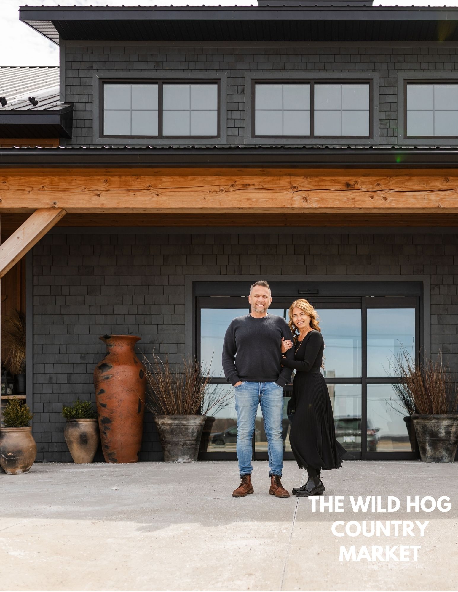 Two people in front of the Wild Hog Country Market building.