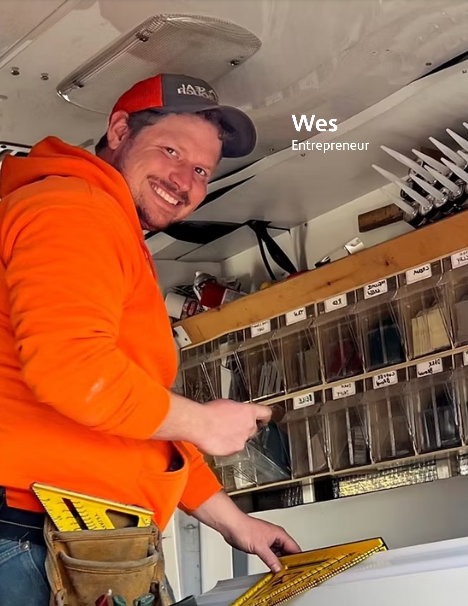 young man standing inside his work truck measuring a piece of trim