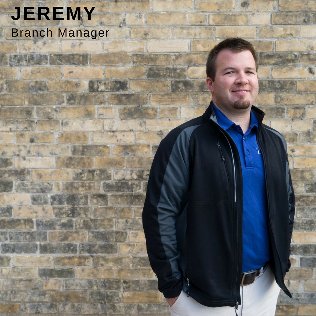 Man smiling in front of brick wall