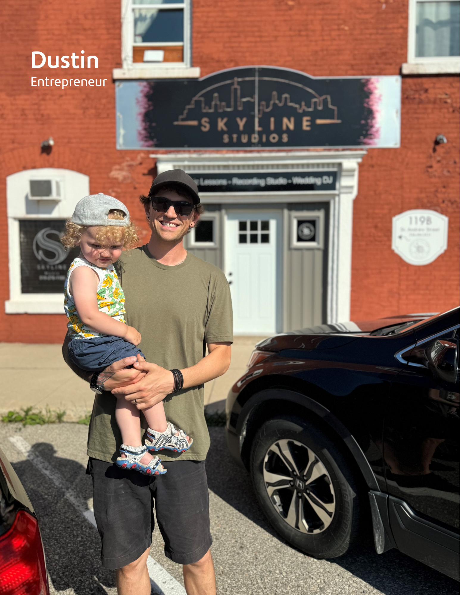 man standing infront of store holding a baby