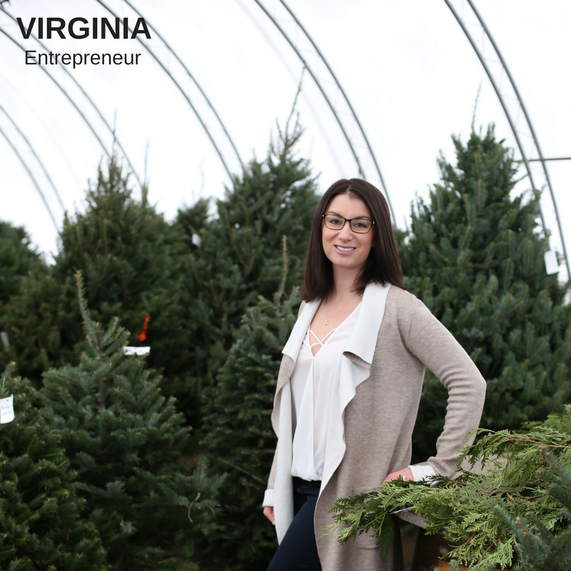 Young woman smiling in front of green pine trees