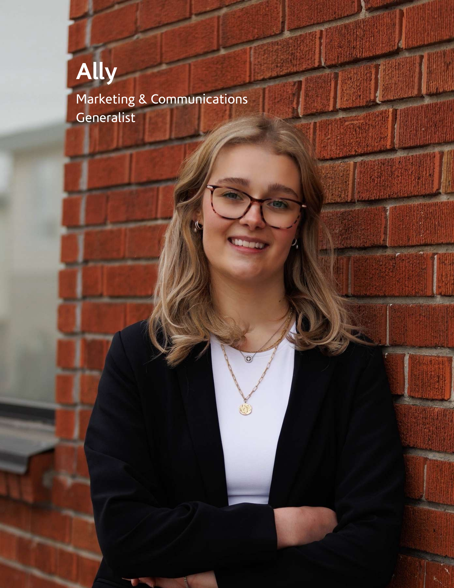 young woman posing infront of brick wall