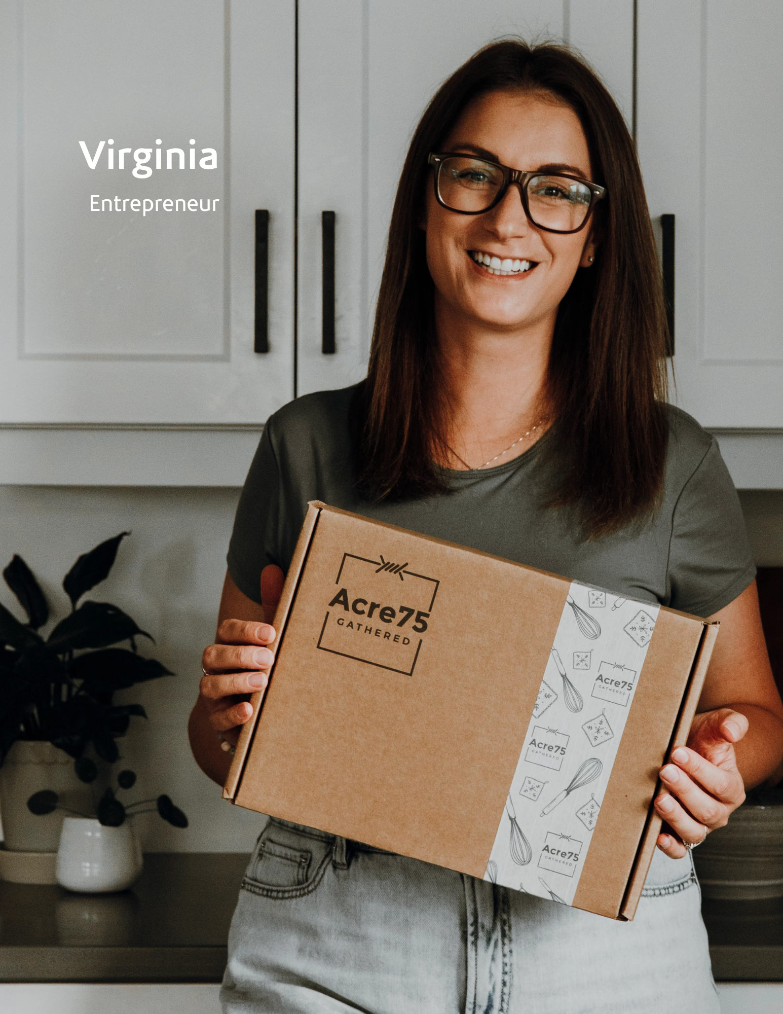 woman standing in her kitchen posing with a box