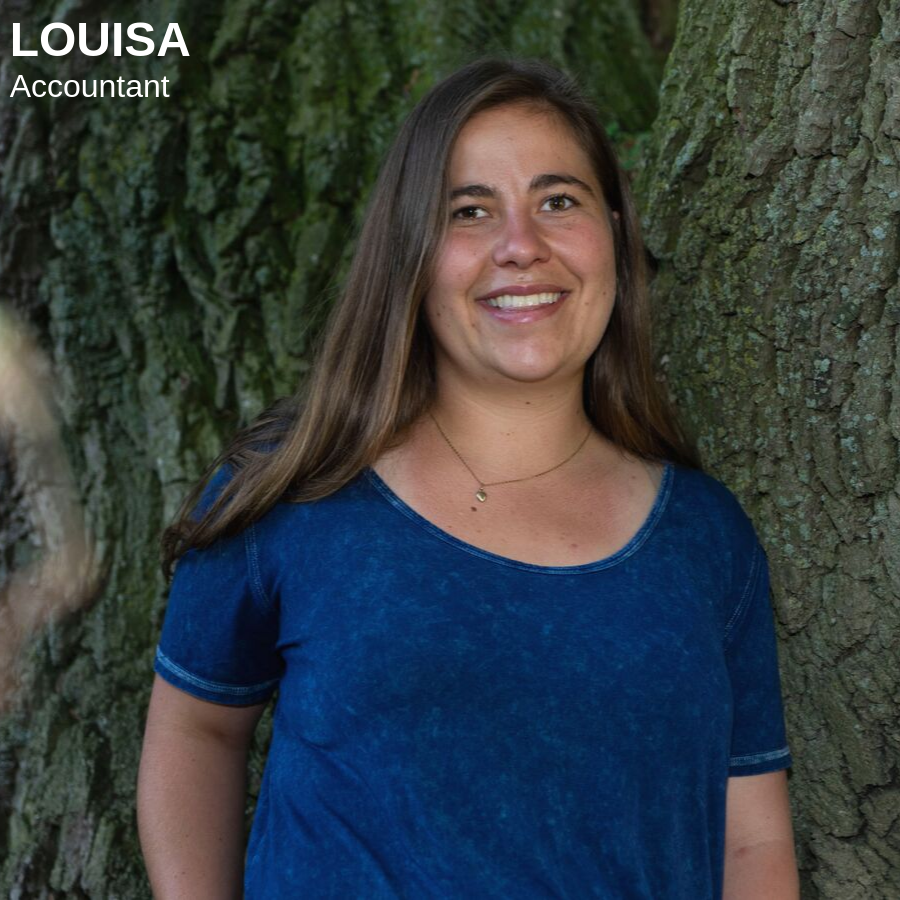 Brunette woman standing in front of a large tree