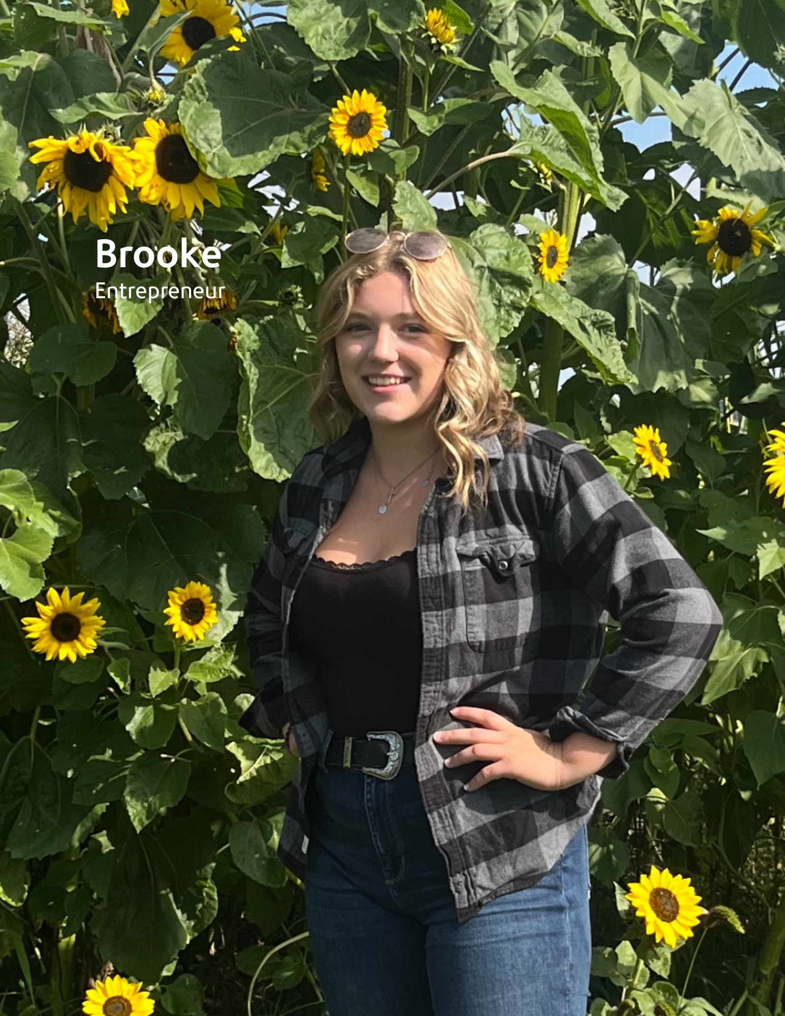 young woman posing in front of field of sunflowers